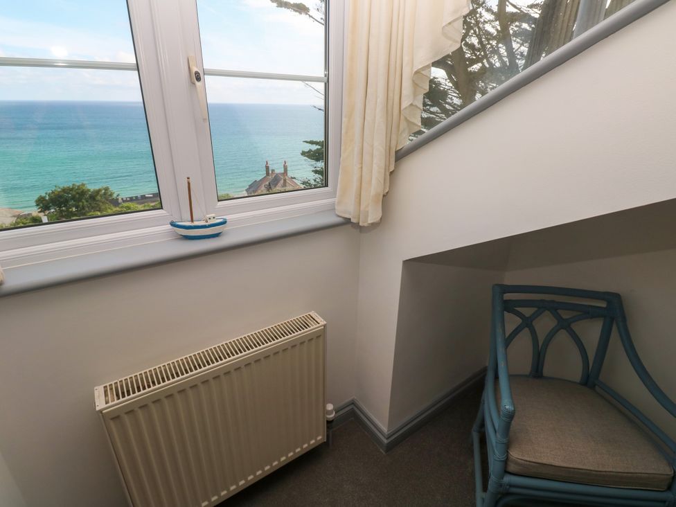 A corner with a chair and a radiator overlooking the sea at Ocean Gem in Carbis Bay