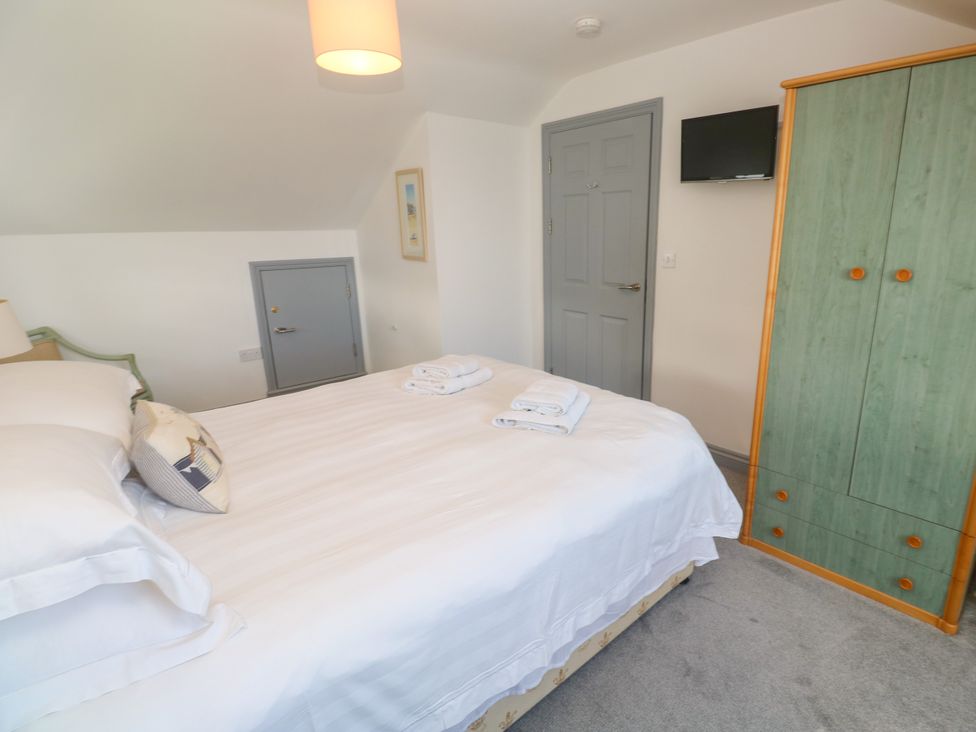 A bedroom with a bed and wardrobe at Ocean Gem in Carbis Bay