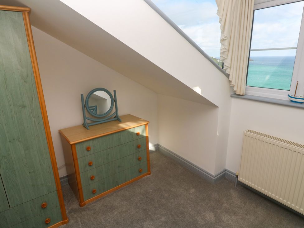 A bedroom with a dresser and a mirror at Ocean Gem in Carbis Bay