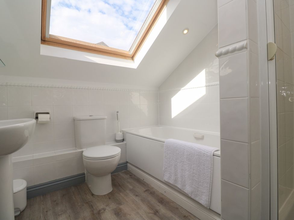A bathroom with a bathtub and toilet at Ocean Gem in Carbis Bay