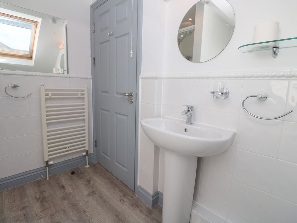 A bathroom with sink, mirror, and towel rail at Ocean Gem in Carbis Bay