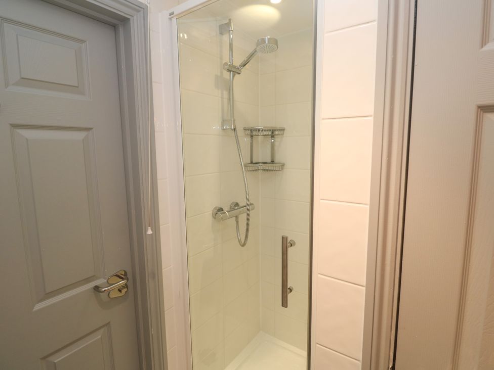 A shower with tiled walls and a door at Ocean Gem in Carbis Bay