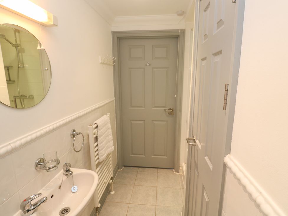 A bathroom with a sink and a mirror at Ocean Gem in Carbis Bay