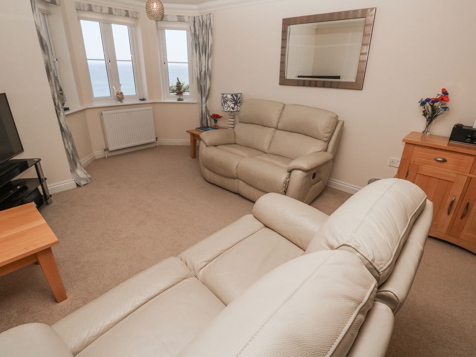 A living room with a sofa and television at Golva in Carbis Bay