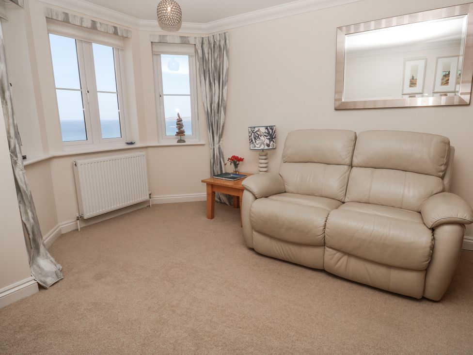 A living room with a sofa and table at Golva in Carbis Bay
