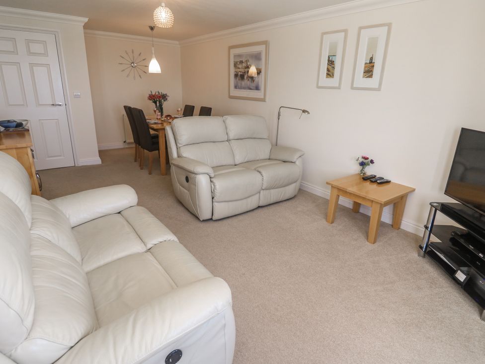 A living room with a sofa and dining area at Golva in Carbis Bay