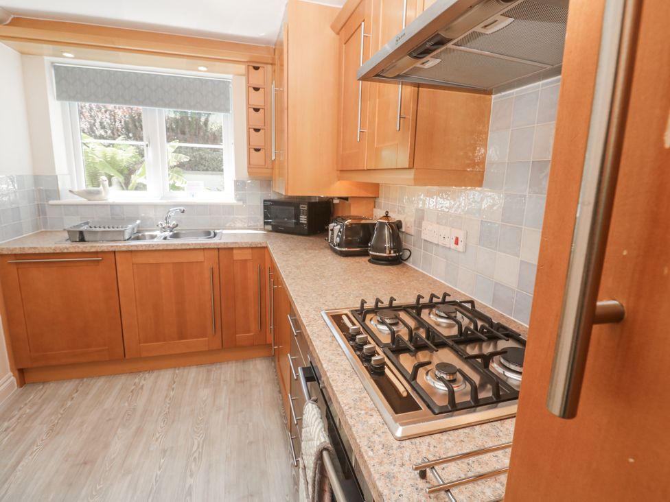A kitchen with wooden cabinets and appliances at Golva in Carbis Bay