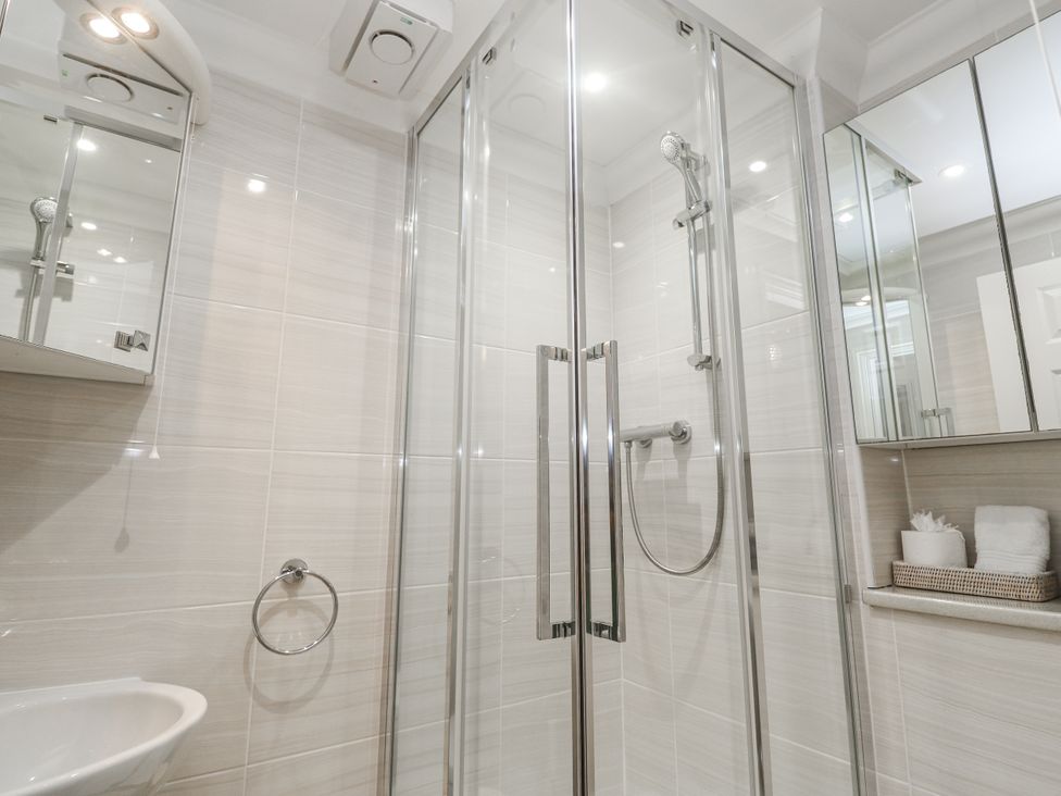 A bathroom with shower and towels at Golva in Carbis Bay