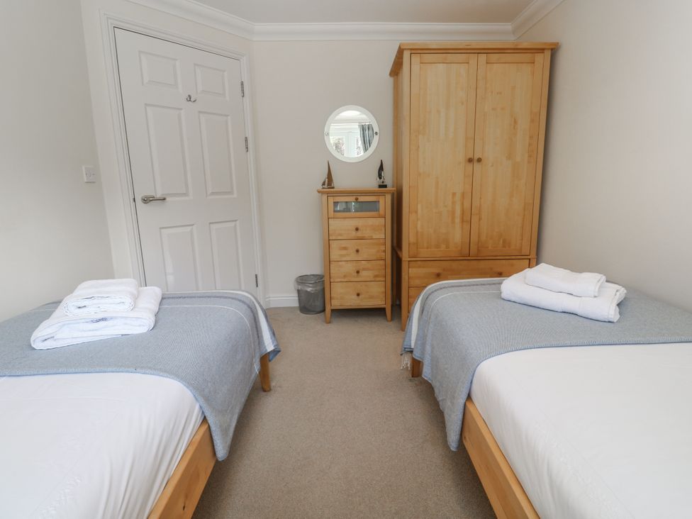 A bedroom with two beds and wooden furniture at Golva in Carbis Bay