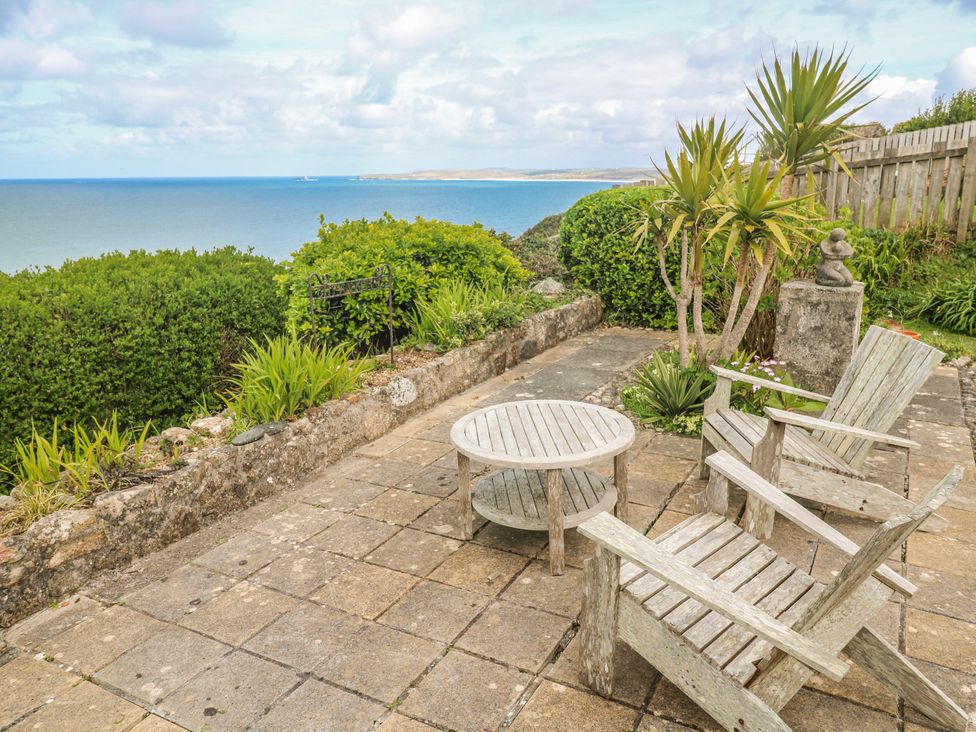 An outdoor seating area with wooden furniture and a sea view at Island View in Carbis Bay