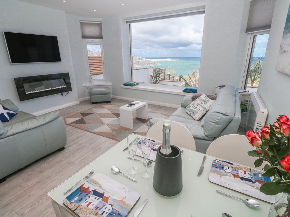 A living room with a sofa and dining table at Island View in Carbis Bay