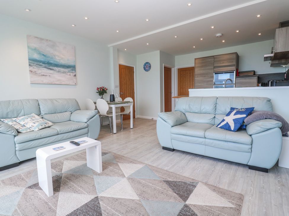 A living room with sofas and a dining table at Island View in Carbis Bay
