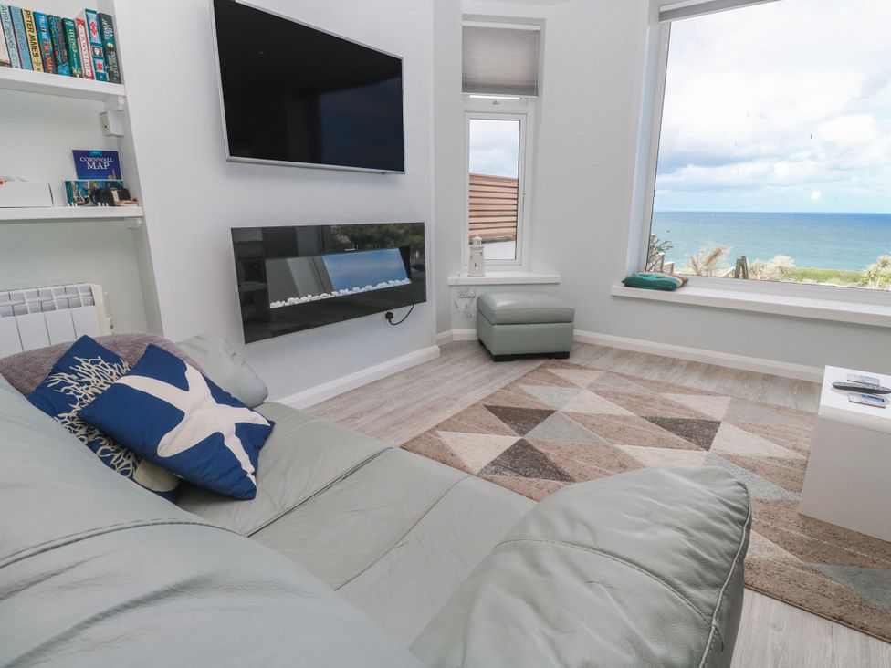 A living room with a television and a seaside view at Island View in Carbis Bay