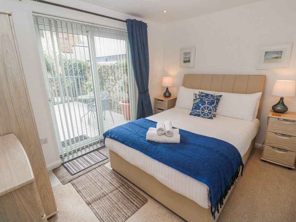 A bedroom with a bed and sliding doors to a patio at Island View in Carbis Bay