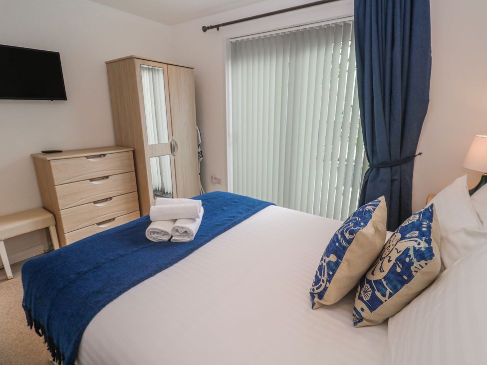A bedroom with a bed, dresser, and TV at Island View in Carbis Bay