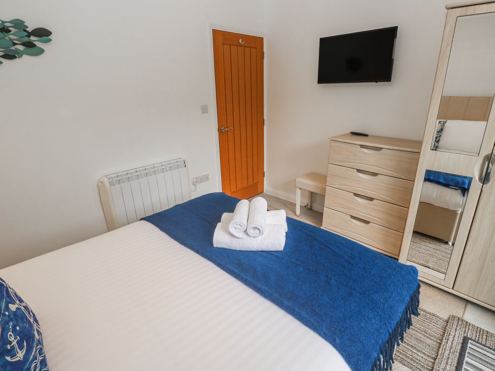 A bedroom with a bed, television, and dresser at Island View in Carbis Bay