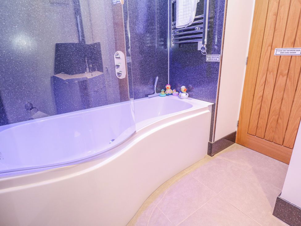 A bathroom with a bathtub and towel warmer at Island View, Carbis Bay