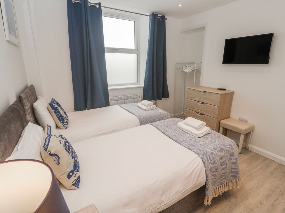 A bedroom with two beds and a television at Island View in Carbis Bay