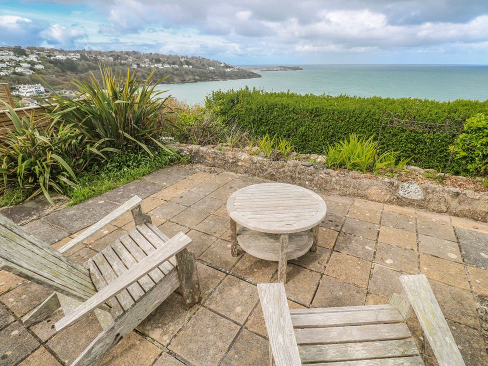 A garden with chairs and a table overlooking the sea at Island View in Carbis Bay