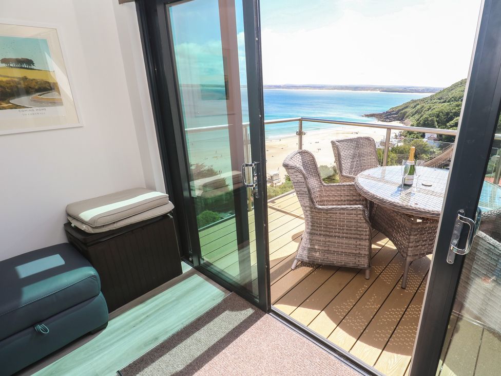 A balcony with a table and chairs at Oceania in St Ives
