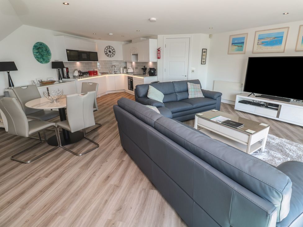 A living room with a sofa and dining table at Oceania St Ives
