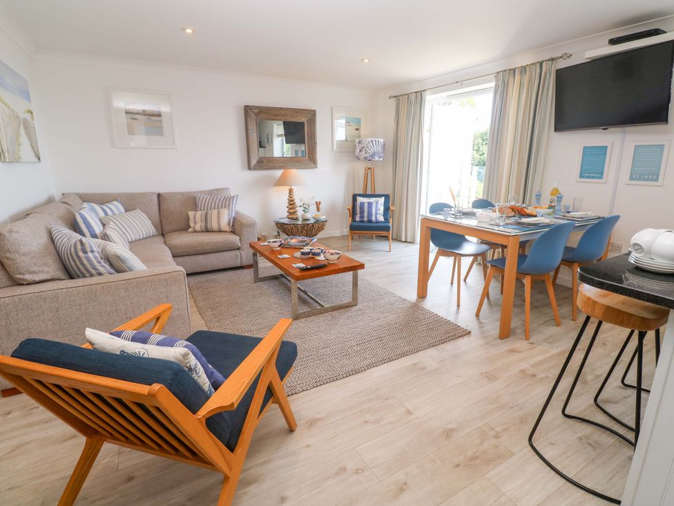 A living room with a sofa and dining table at Sea Breeze in Carbis Bay