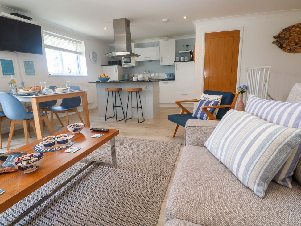 A living room with a sofa and dining area at Sea Breeze in Carbis Bay