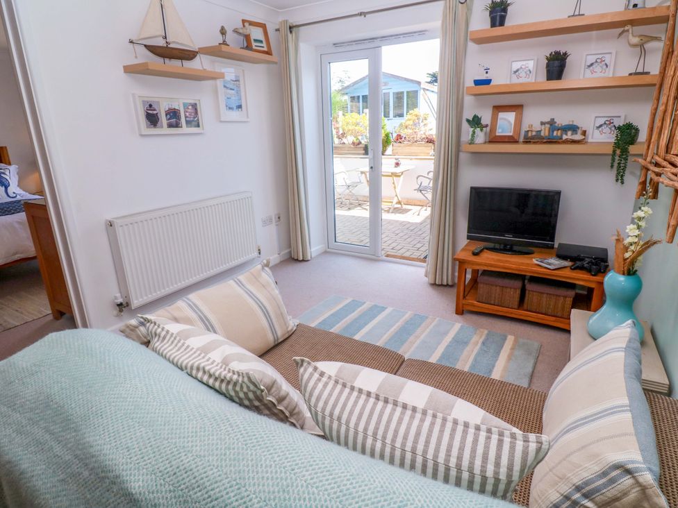 A living room with a sofa and television at Sea Breeze in Carbis Bay