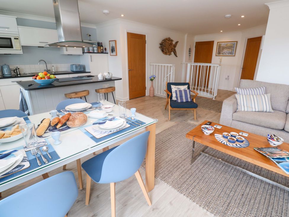 A dining area with table and chairs and a living space at Sea Breeze in Carbis Bay