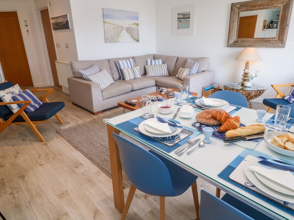 A dining room with a dining table and sofa at Sea Breeze in Carbis Bay