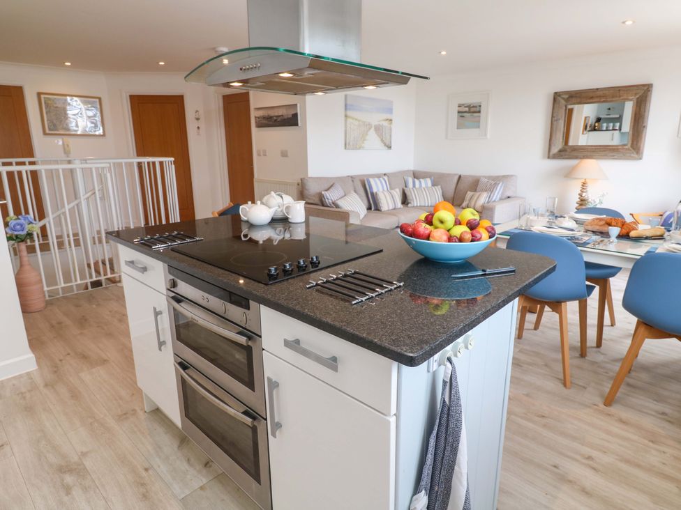 A kitchen with an island and dining area at Sea Breeze in Carbis Bay
