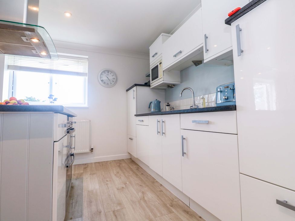 A kitchen with a sink and microwave at Sea Breeze in Carbis Bay