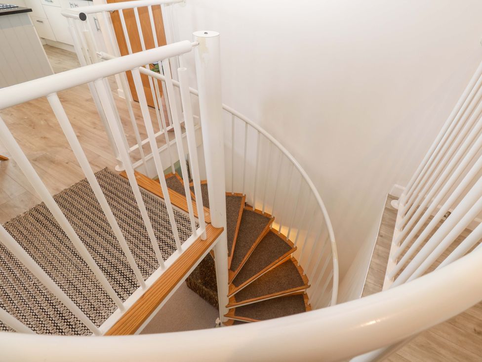 A staircase with a circular design and wooden steps at Sea Breeze, Carbis Bay