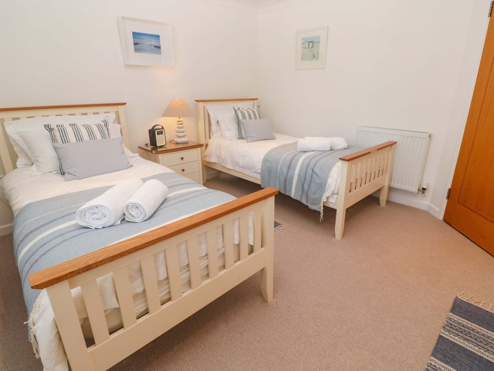 A bedroom with two beds and a nightstand at Sea Breeze in Carbis Bay
