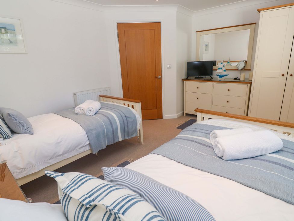 A bedroom with two beds and a television at Sea Breeze in Carbis Bay