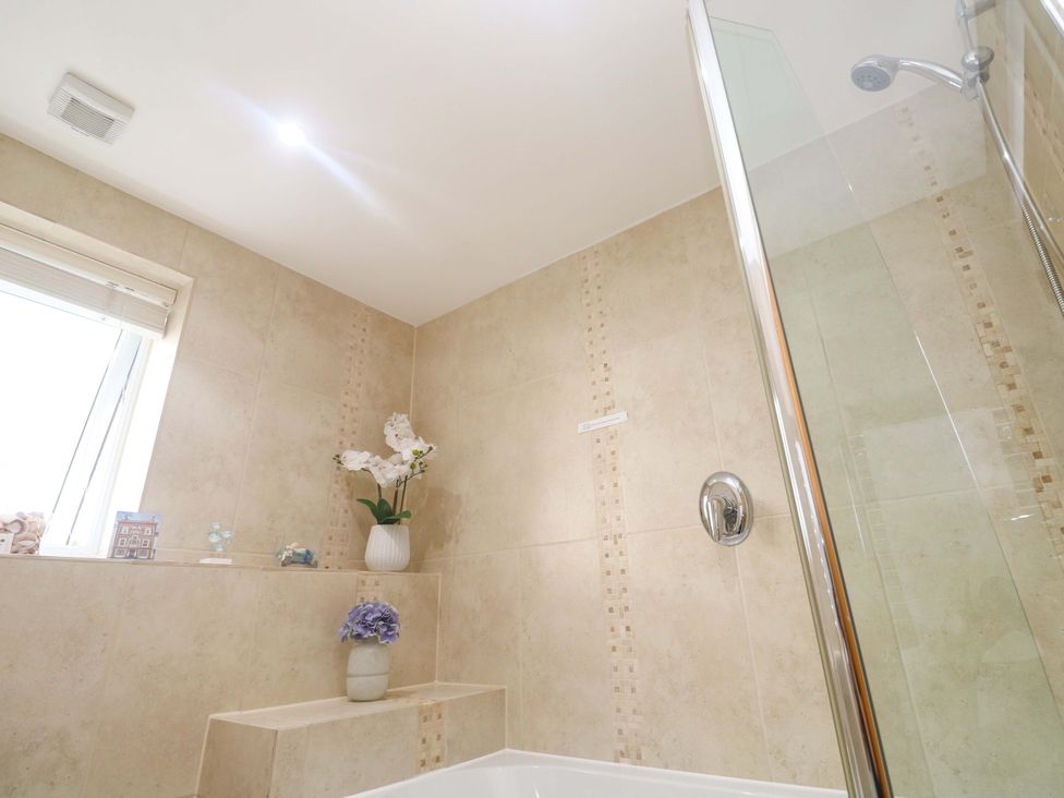 A bathroom with a shower and bathtub at Sea Breeze in Carbis Bay