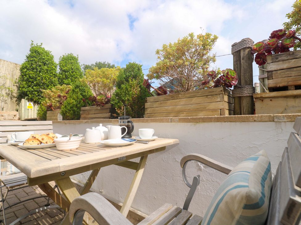 An outdoor seating area with a table and treats at Sea Breeze in Carbis Bay