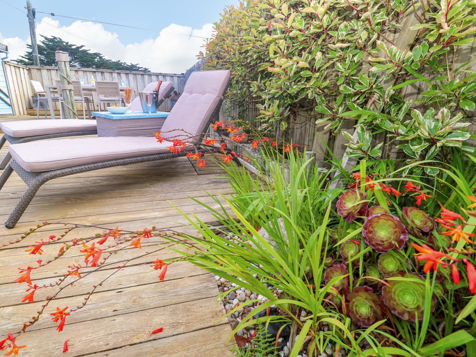 An outdoor space with sun loungers and dining area at Sea Breeze in Carbis Bay