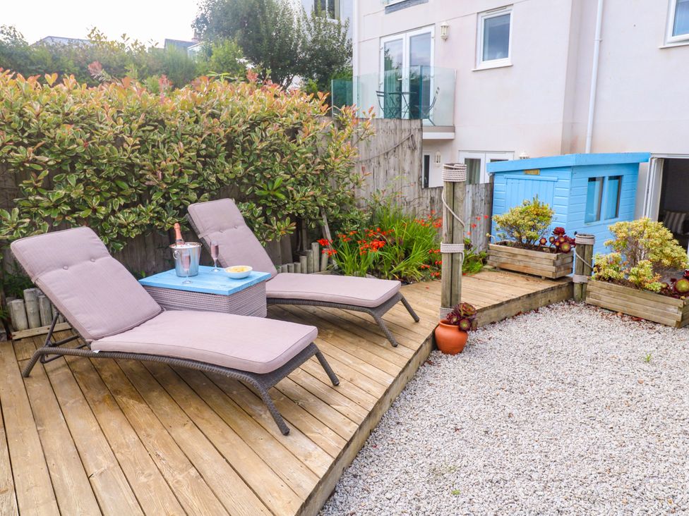 A garden with lounge chairs and a table at Sea Breeze in Carbis Bay