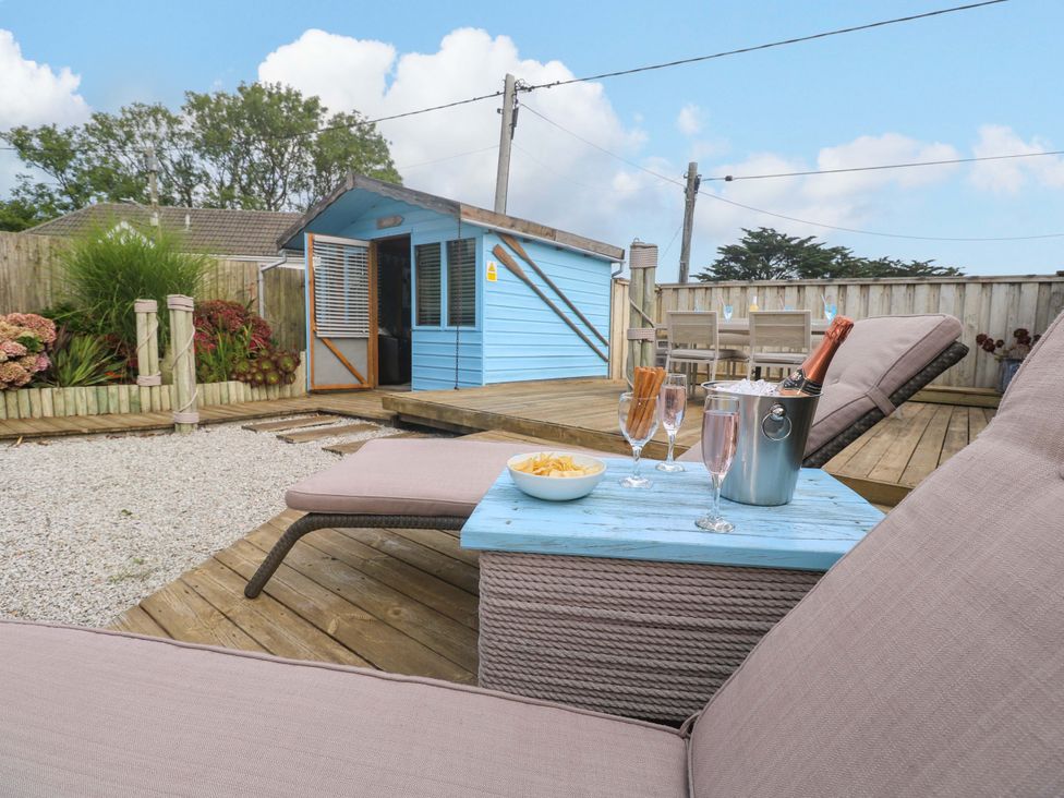 A garden with sun loungers and a blue cabana at Sea Breeze in Carbis Bay