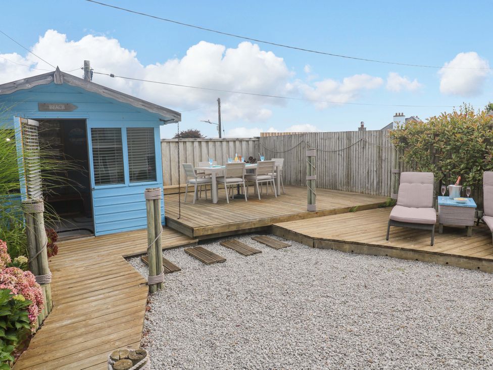 A garden with a blue shed and dining area at Sea Breeze in Carbis Bay