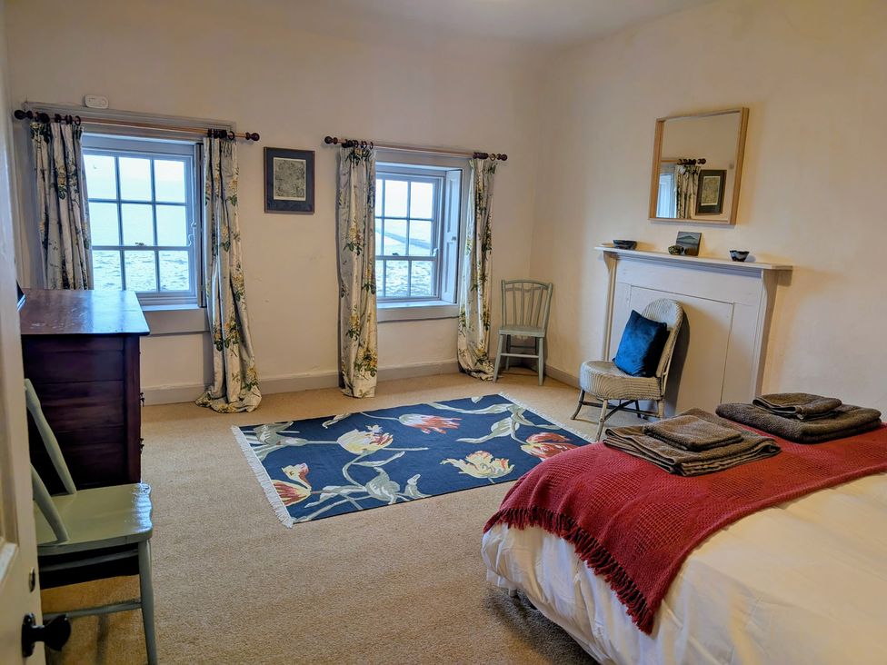 A bedroom with a bed and windows at The Ferry House, Ramelton, County Donegal