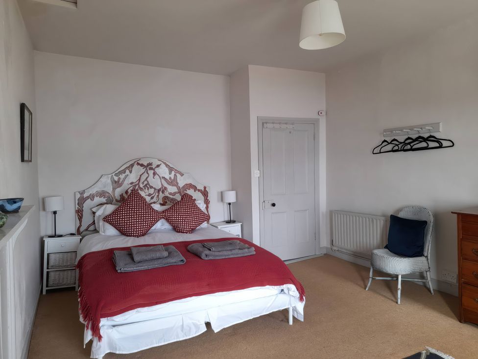 A bedroom with a bed and chair at The Ferry House in Ramelton, County Donegal
