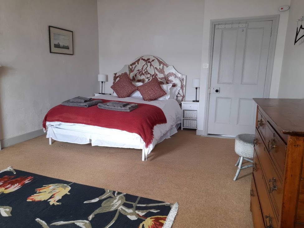 A bedroom with a bed and dresser at The Ferry House in Ramelton, County Donegal