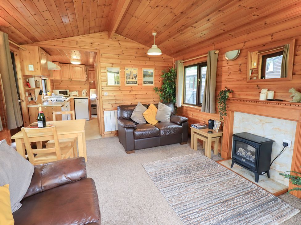 A living room with a sofa and dining table at Squirrels Leap near Number 29, Burnside Park near Keswick