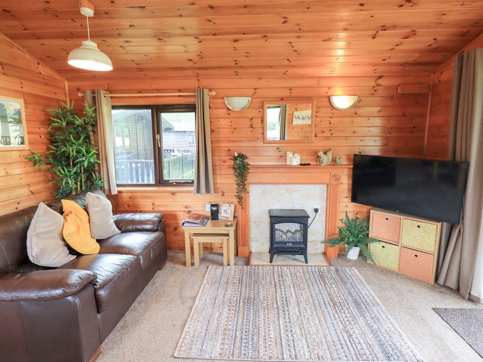 A living room with a sofa and fireplace at Squirrels Leap near Keswick