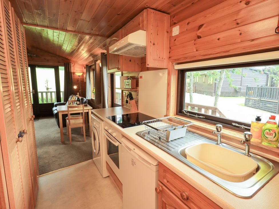 A kitchen with sink and dining table at Squirrels Leap, Number 29, Burnside Park near Keswick