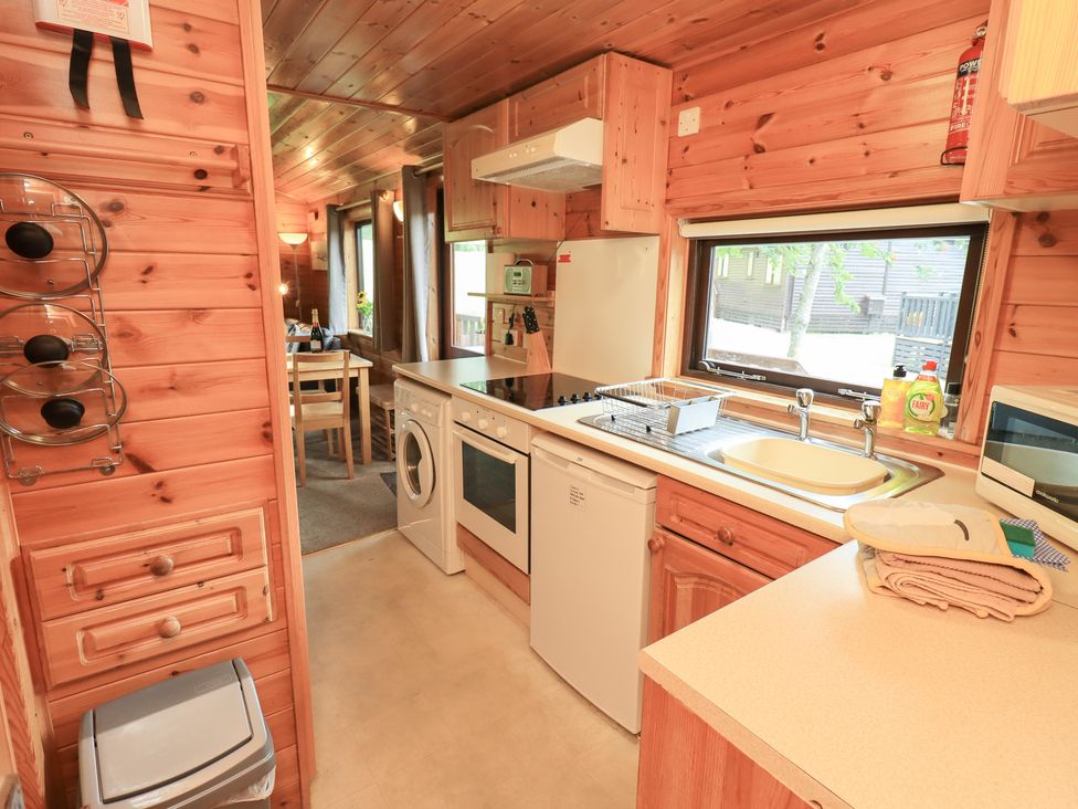 A kitchen with various appliances and a dining area at Squirrels Leap, Number 29, Burnside Park near Keswick
