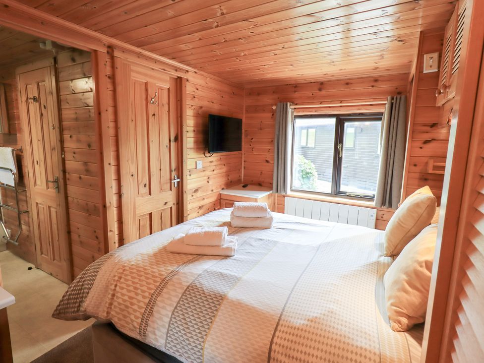 A bedroom with a bed and television at Squirrels Leap Number 29, Burnside Park near Keswick