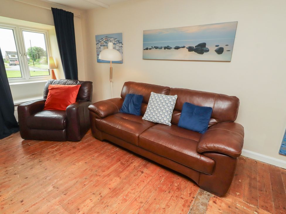 A living room with a leather sofa and an armchair at ASTA COTTAGE Cresswell